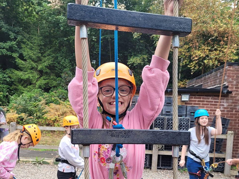 Young person climbing a rope ladder