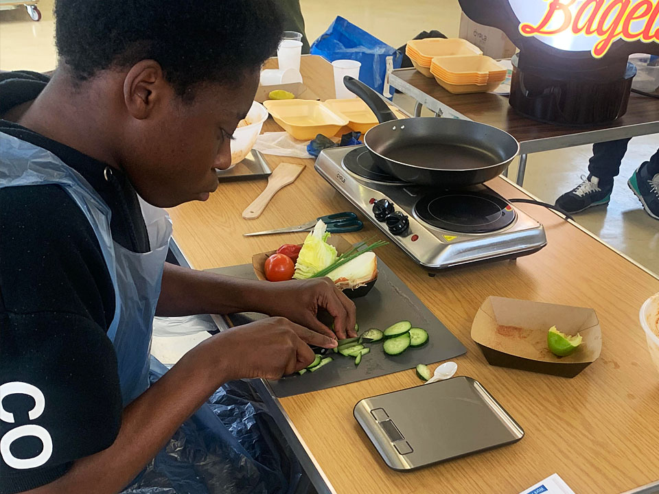 Young person cooking jerk chicken bagels
