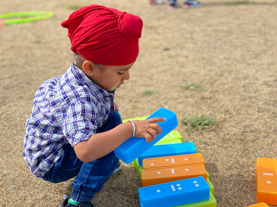 Child playing with large plastic dominoes