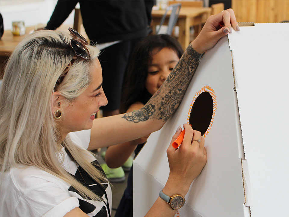 Powered by CAN volunteer working with children to create a cardboard house