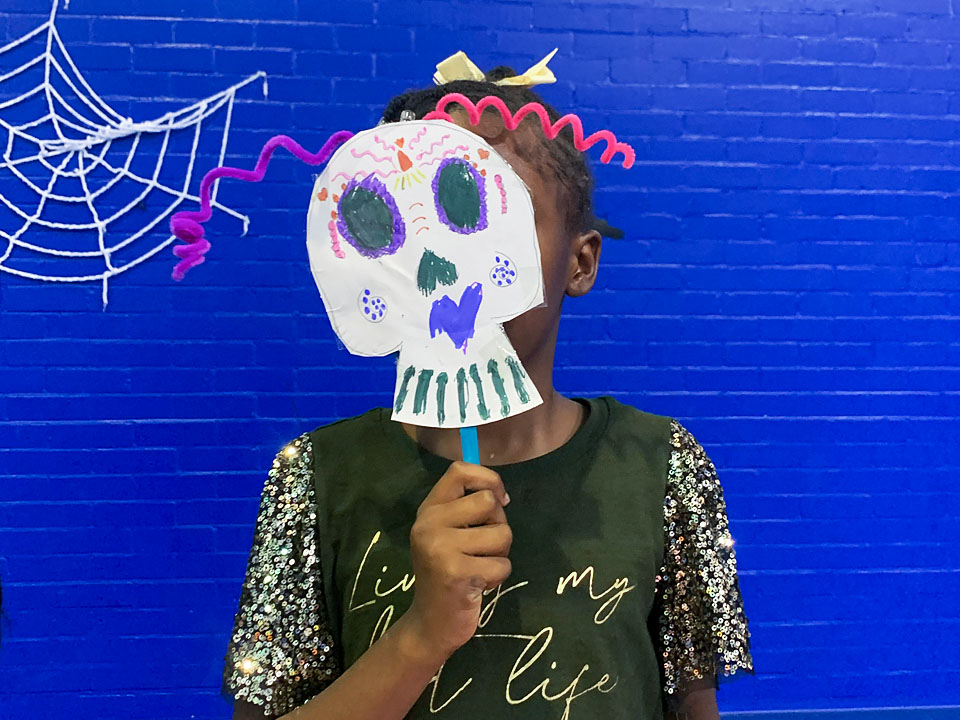 Young person with a hand made halloween skull mask